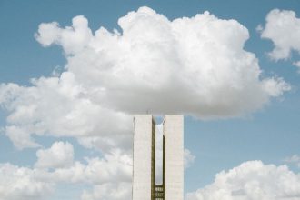 Congresso Nacional em Brasília sob céu com nuvens.