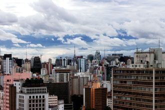 Vista panorâmica de São Paulo, com edifícios altos sob um céu nublado.